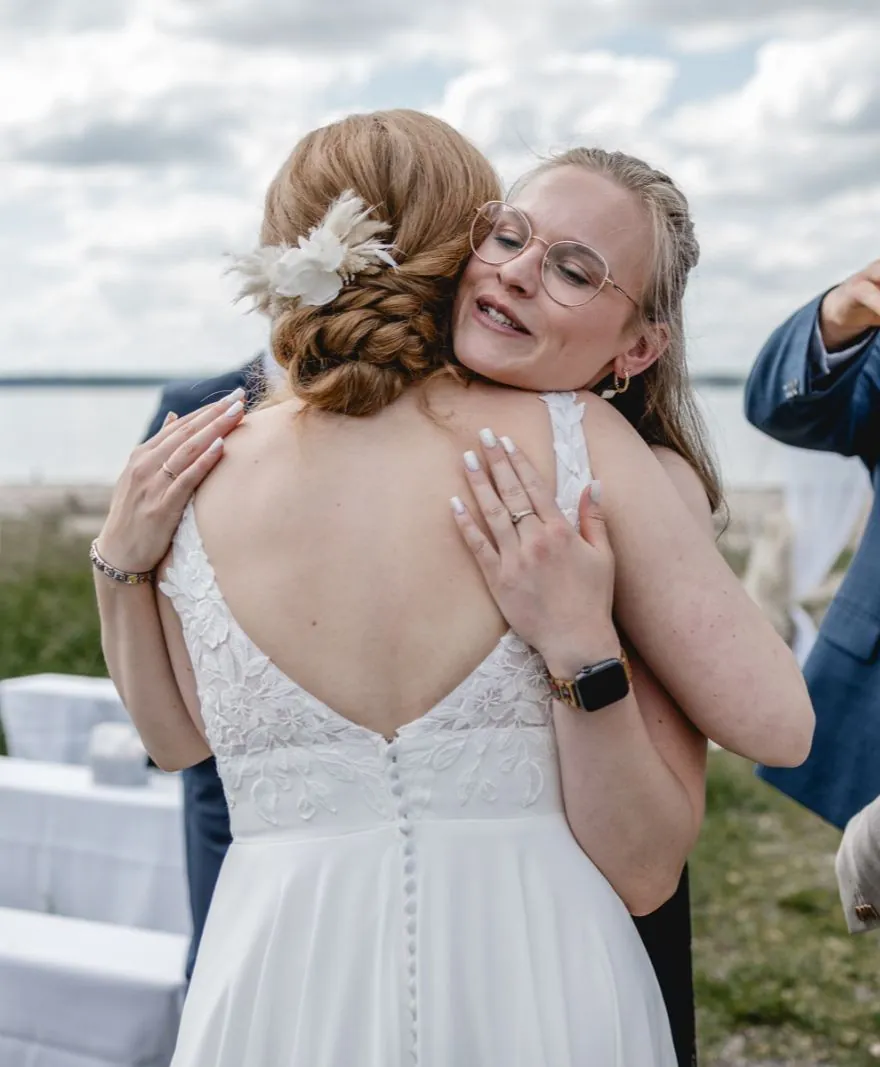 Braut umarmt Emma nach der Trauung an der Ostsee